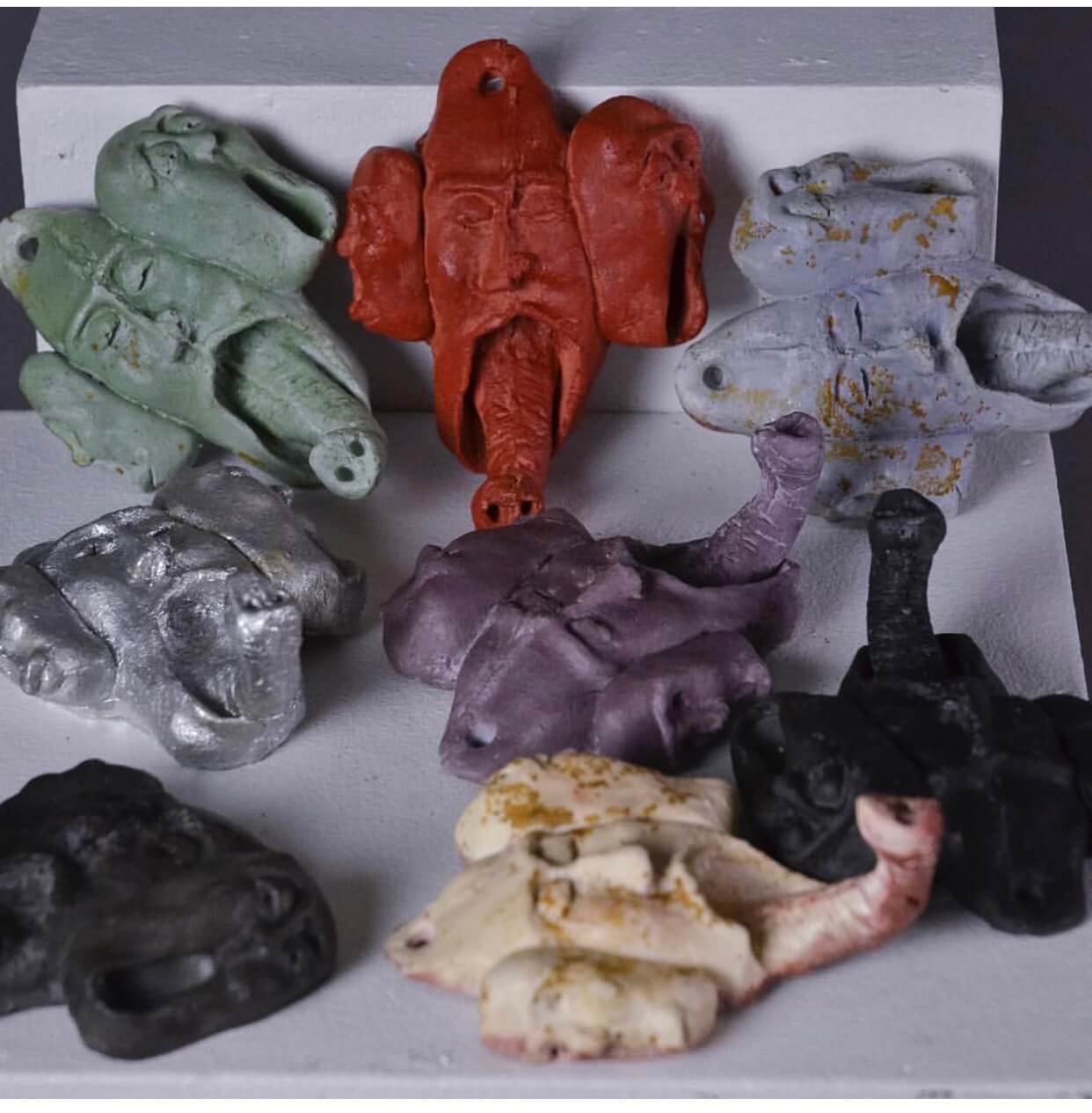 multiple coat hangers in shapes of faces merged with elephant noses in different colours
